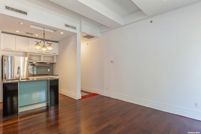 bar with stainless steel refrigerator, hanging light fixtures, dark hardwood / wood-style flooring, backsplash, and white cabinets