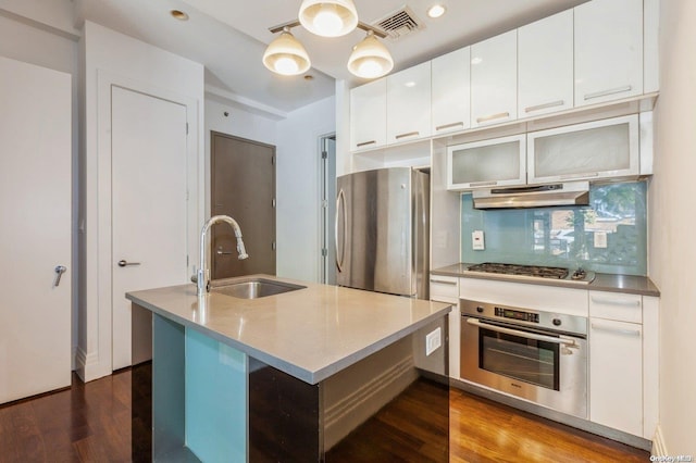 kitchen featuring white cabinets, appliances with stainless steel finishes, hardwood / wood-style flooring, and sink