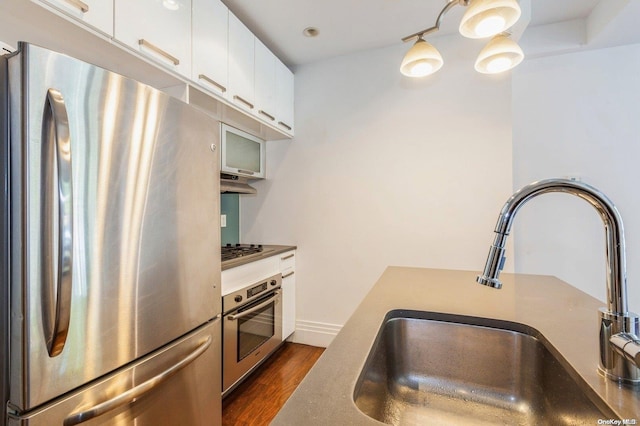 kitchen with dark hardwood / wood-style flooring, white cabinetry, sink, and appliances with stainless steel finishes