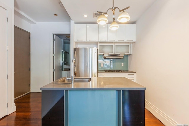 kitchen featuring white cabinets, stainless steel refrigerator, and sink