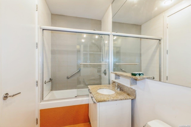 full bathroom featuring vanity, toilet, and bath / shower combo with glass door