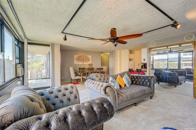 living room with ceiling fan, light carpet, and a textured ceiling