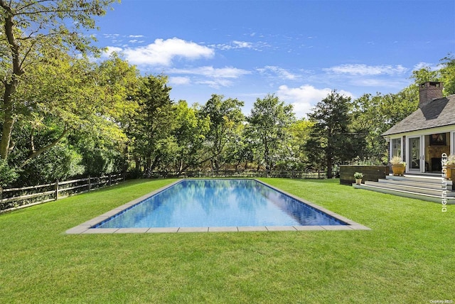 view of pool with a yard