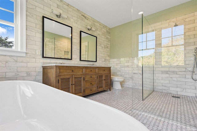 full bathroom with vanity, independent shower and bath, tile walls, and toilet