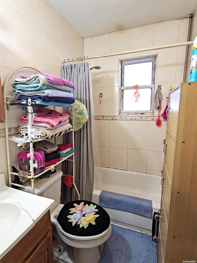 full bathroom featuring shower / bath combination with curtain, vanity, toilet, and tile walls