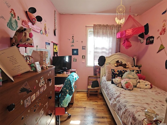 bedroom with a chandelier and light hardwood / wood-style floors