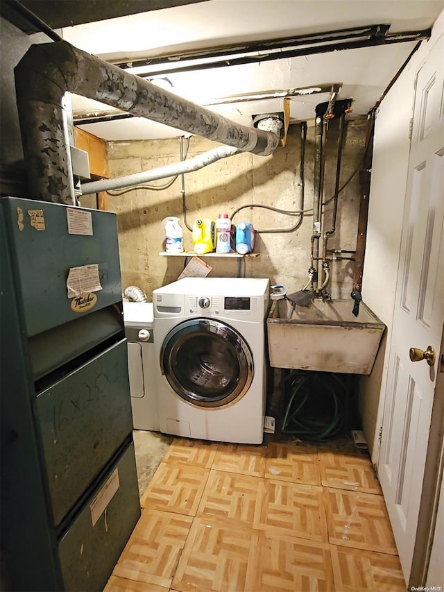 clothes washing area featuring light parquet flooring, washer / clothes dryer, and sink