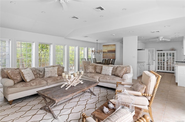 tiled living room featuring ceiling fan with notable chandelier