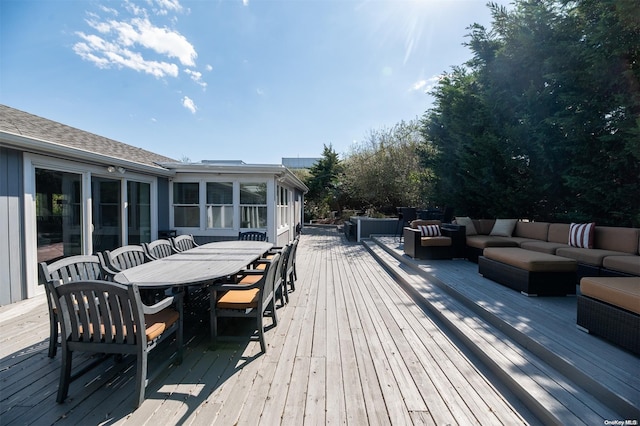 wooden terrace with an outdoor hangout area and a sunroom