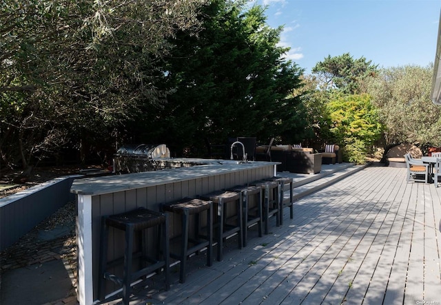 view of pool featuring an outdoor bar, grilling area, and a wooden deck