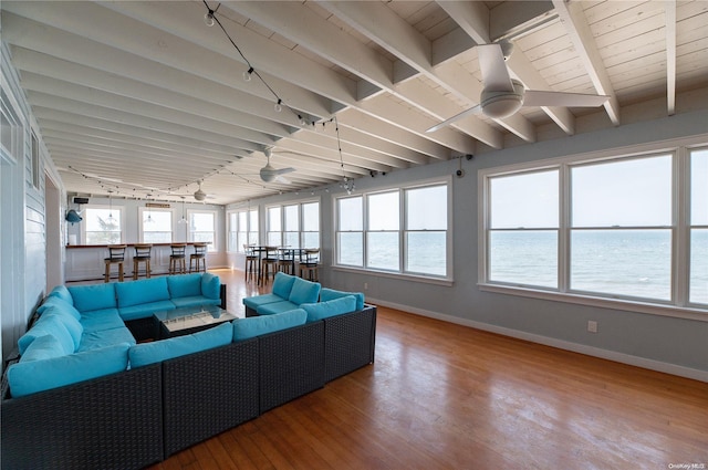 sunroom / solarium with beamed ceiling, a water view, and ceiling fan