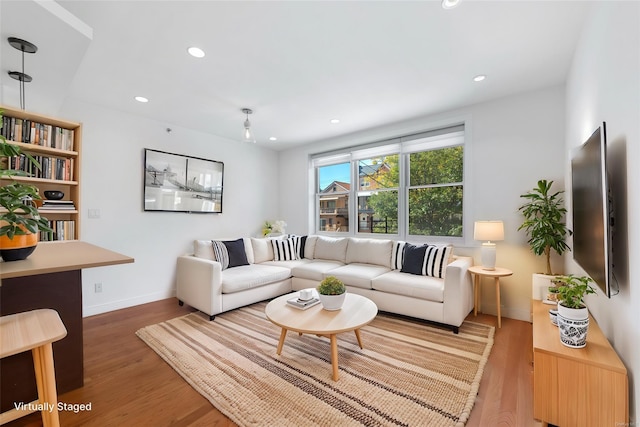 living area featuring recessed lighting, light wood-type flooring, and baseboards