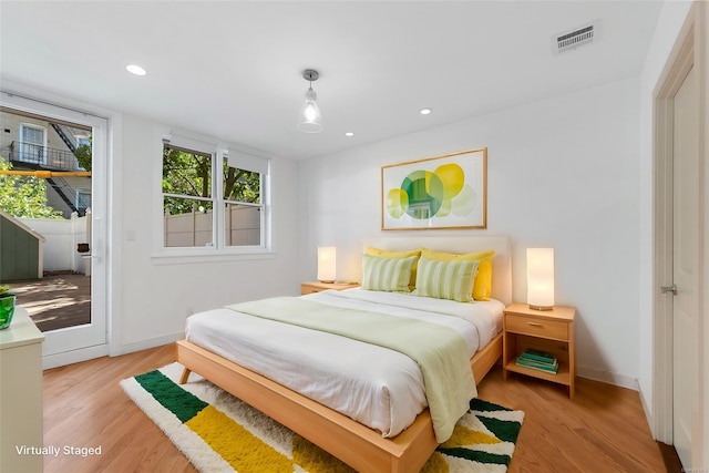 bedroom with visible vents, recessed lighting, light wood-style floors, baseboards, and access to exterior