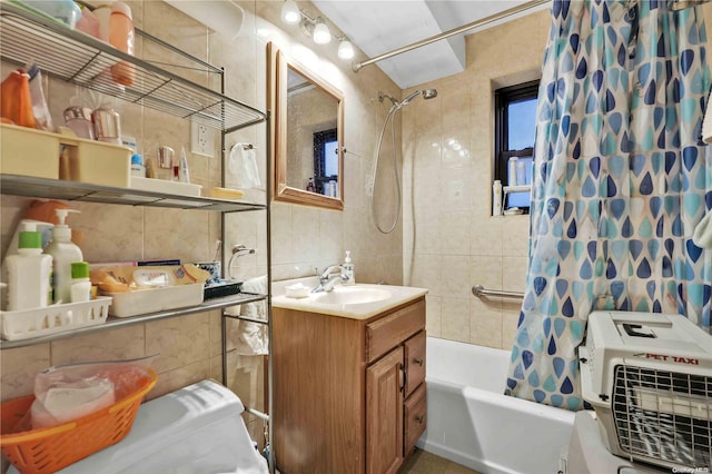 bathroom with shower / bath combo, vanity, tasteful backsplash, and tile walls