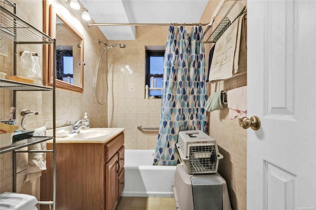 bathroom featuring vanity, shower / bath combo with shower curtain, tile walls, and tasteful backsplash