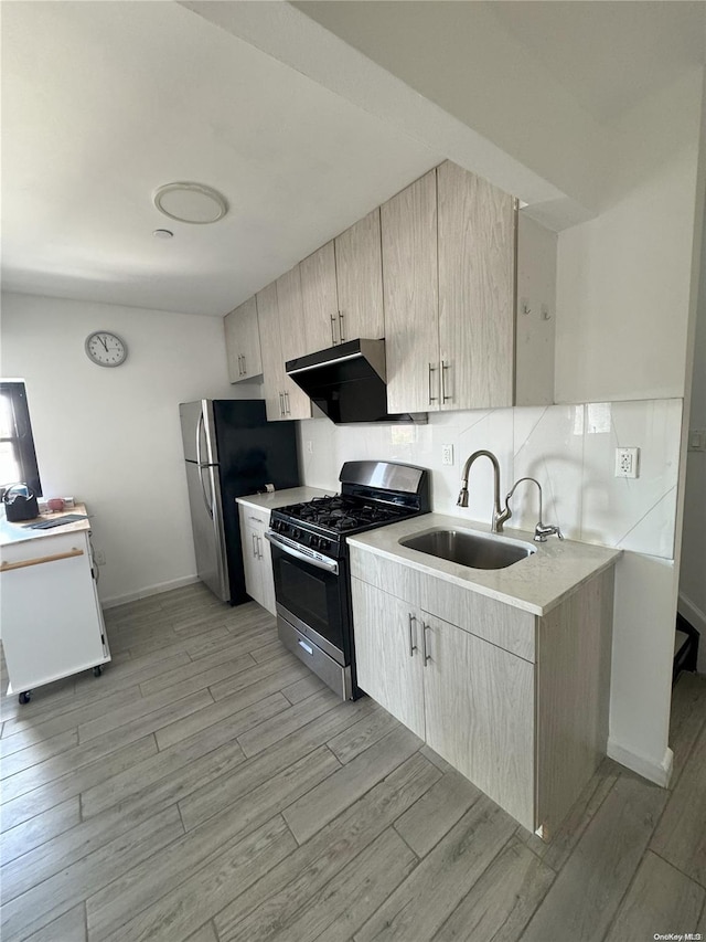 kitchen featuring sink, stainless steel appliances, light brown cabinets, and light hardwood / wood-style floors