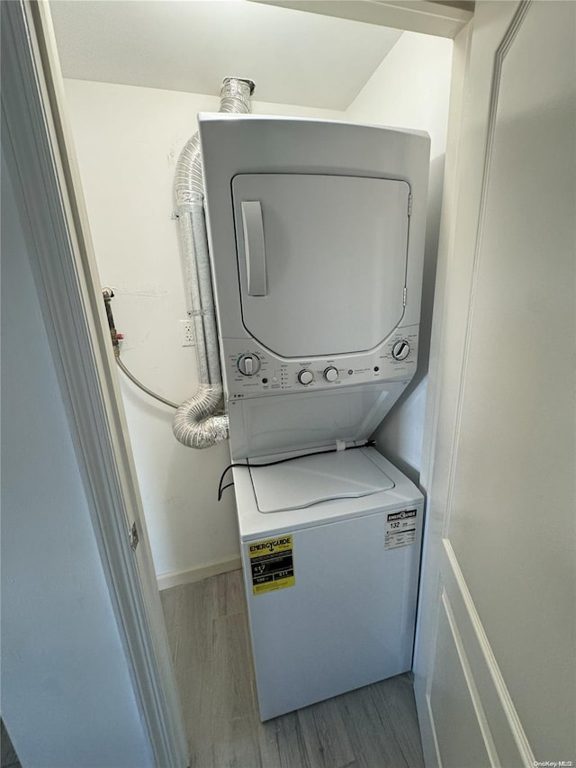 laundry area with stacked washing maching and dryer and light hardwood / wood-style flooring