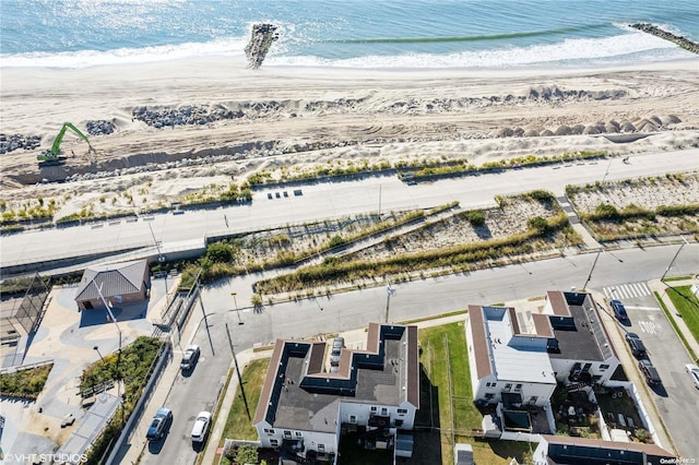 drone / aerial view featuring a water view and a beach view