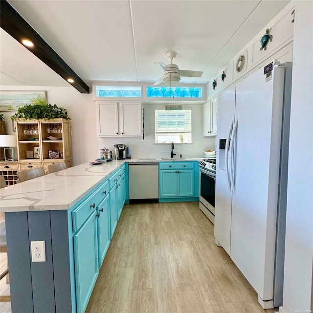 kitchen with ceiling fan, kitchen peninsula, appliances with stainless steel finishes, white cabinets, and light wood-type flooring