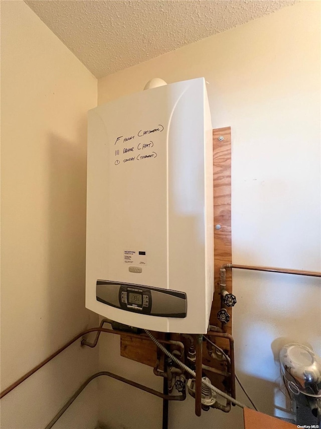 room details featuring a textured ceiling and tankless water heater