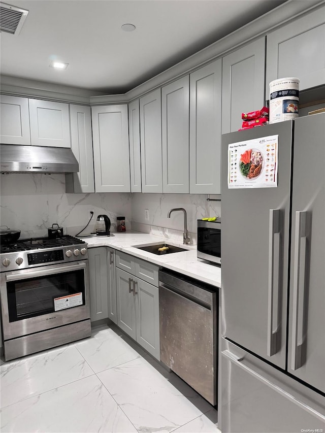 kitchen featuring backsplash, appliances with stainless steel finishes, sink, and gray cabinets