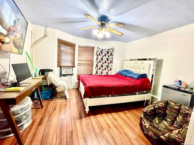 bedroom featuring hardwood / wood-style floors, ceiling fan, and a textured ceiling