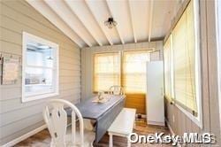 dining area with wooden walls and vaulted ceiling