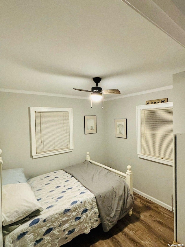 bedroom with dark hardwood / wood-style flooring, ceiling fan, and ornamental molding