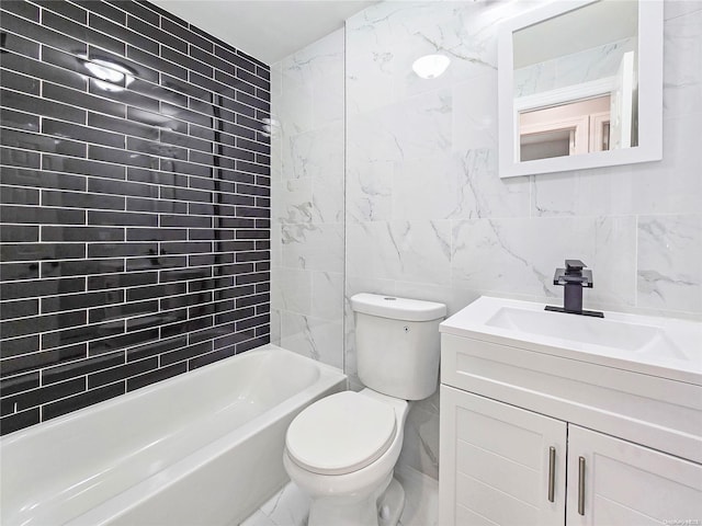 full bathroom featuring tiled shower / bath, vanity, toilet, and tile walls