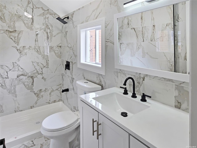 bathroom featuring vanity, toilet, tile walls, and a tile shower