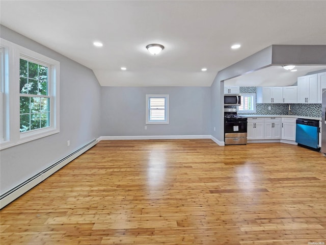 kitchen featuring plenty of natural light, white cabinetry, lofted ceiling, and appliances with stainless steel finishes