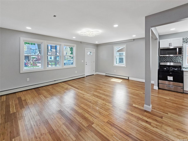 unfurnished living room featuring light hardwood / wood-style flooring and a baseboard heating unit