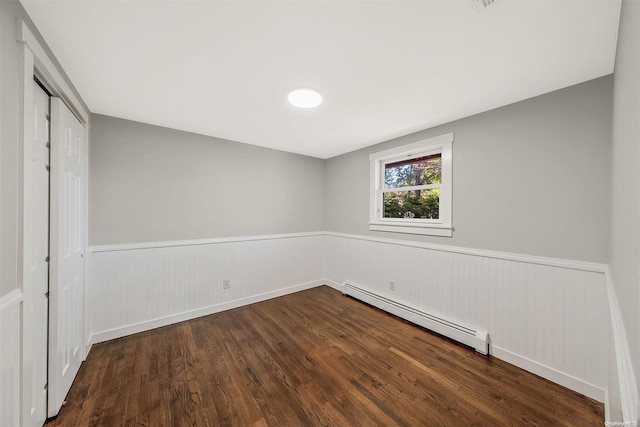 interior space with dark hardwood / wood-style floors, a closet, and a baseboard heating unit