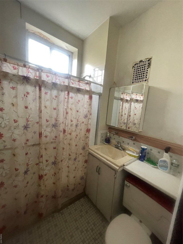 bathroom featuring tasteful backsplash, vanity, toilet, and curtained shower