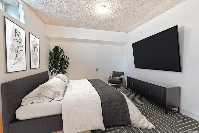 bedroom featuring dark carpet and a textured ceiling