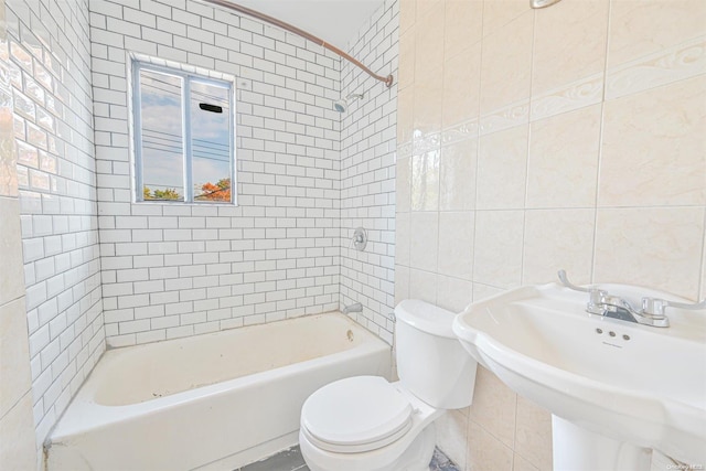 full bathroom with sink, toilet, tile walls, and tiled shower / bath