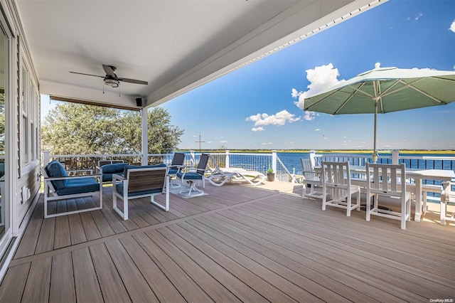 deck featuring an outdoor living space, a water view, and ceiling fan