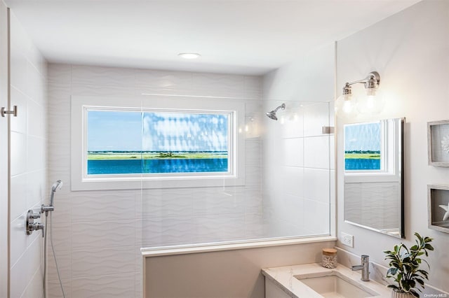 bathroom featuring a tile shower and vanity