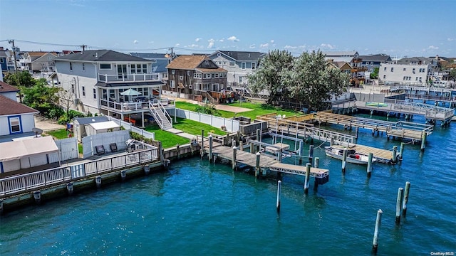 view of dock with a balcony and a water view