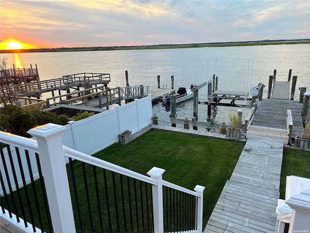 dock area featuring a water view and a lawn