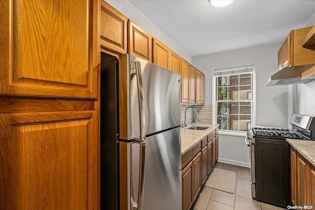 kitchen featuring sink, stainless steel appliances, tasteful backsplash, light stone counters, and light tile patterned flooring