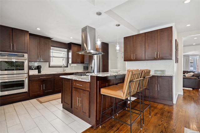 92-52 219th St, Queens Village, NY 11428 - kitchen with appliances with stainless steel finishes, island range hood, a sink, tasteful backsplash, and recessed lighting