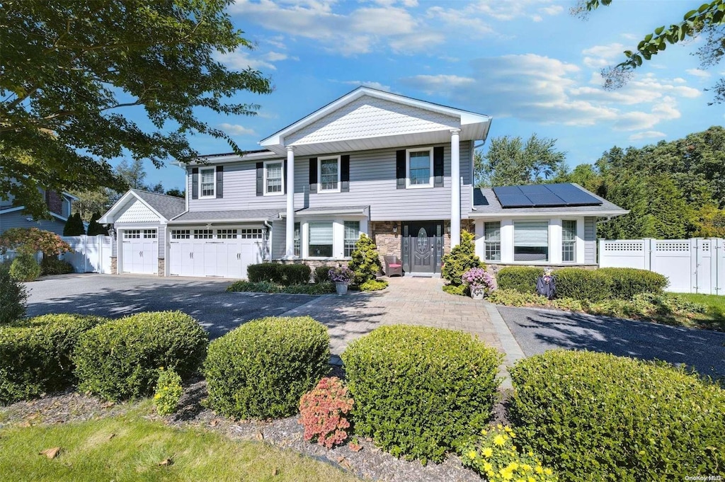 view of front of property featuring a garage and solar panels