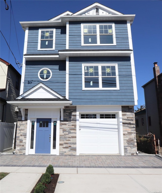54 N Blvd, East Rockaway, NY 11518 - view of front of house featuring stone siding, an attached garage, and driveway