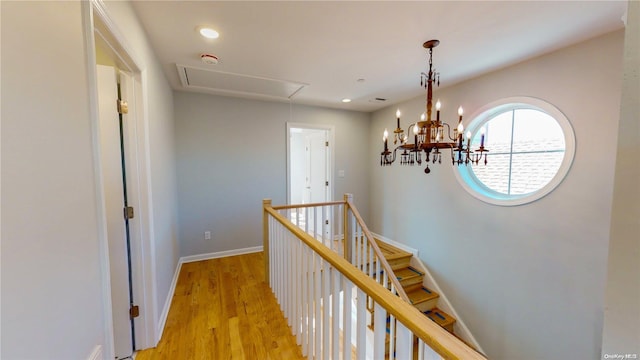 corridor featuring a notable chandelier and light hardwood / wood-style floors