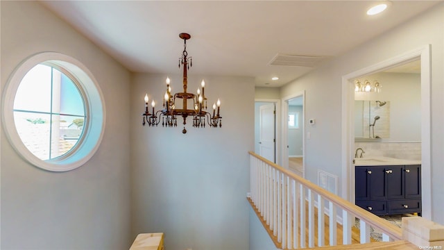 hall featuring a chandelier and sink