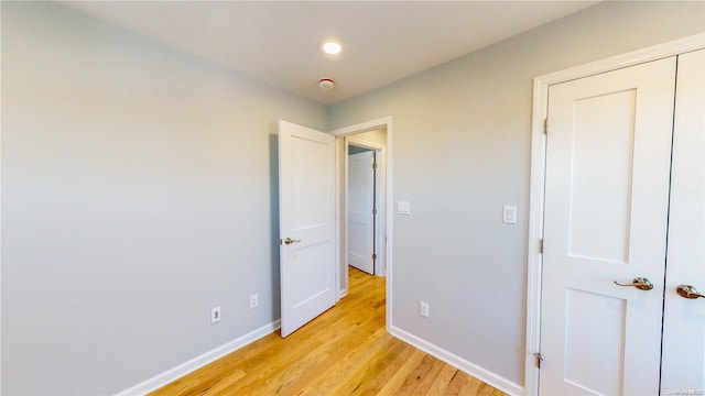 unfurnished bedroom with a closet and light hardwood / wood-style floors