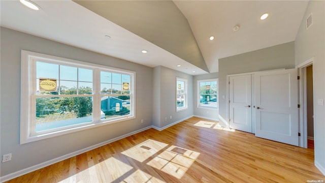 interior space featuring light hardwood / wood-style floors and high vaulted ceiling