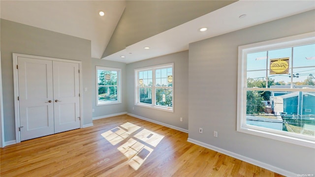 interior space with light wood-type flooring and lofted ceiling