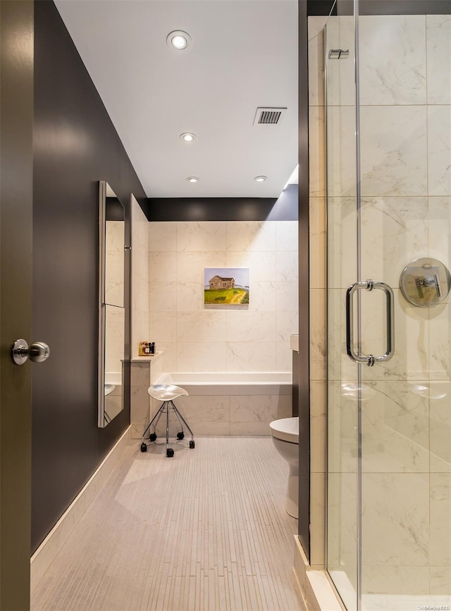 bathroom featuring toilet, tile patterned floors, and separate shower and tub